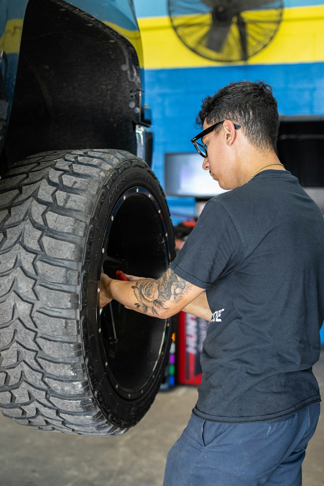 portfolio-04 a-man-working-on-a-tire-in-a-garage-lxd2okt3-ee